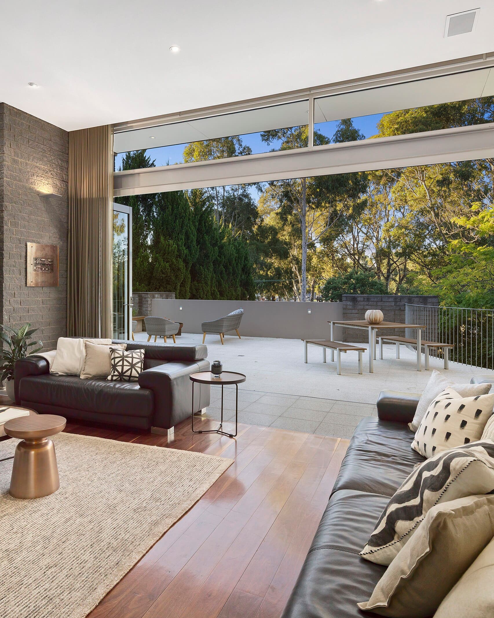 Living room opening onto a stone-paved terrace among gum trees, Eaglemont