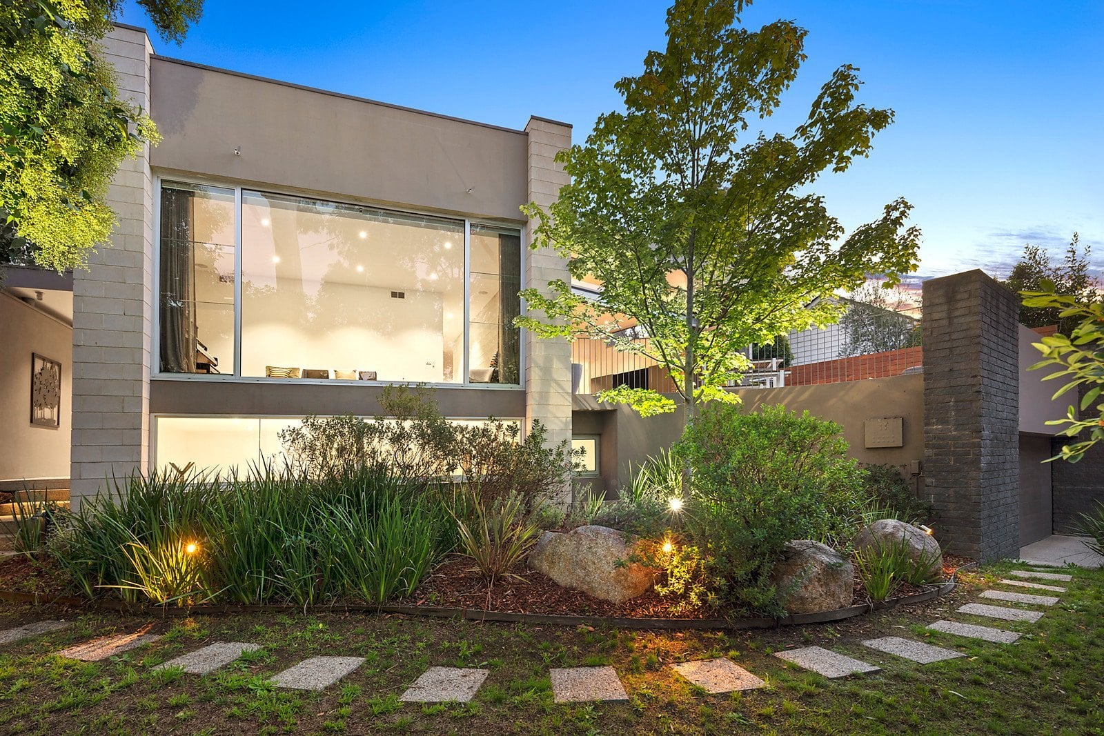 Lit stepping-stone path through the garden to the house at dusk, Eaglemont