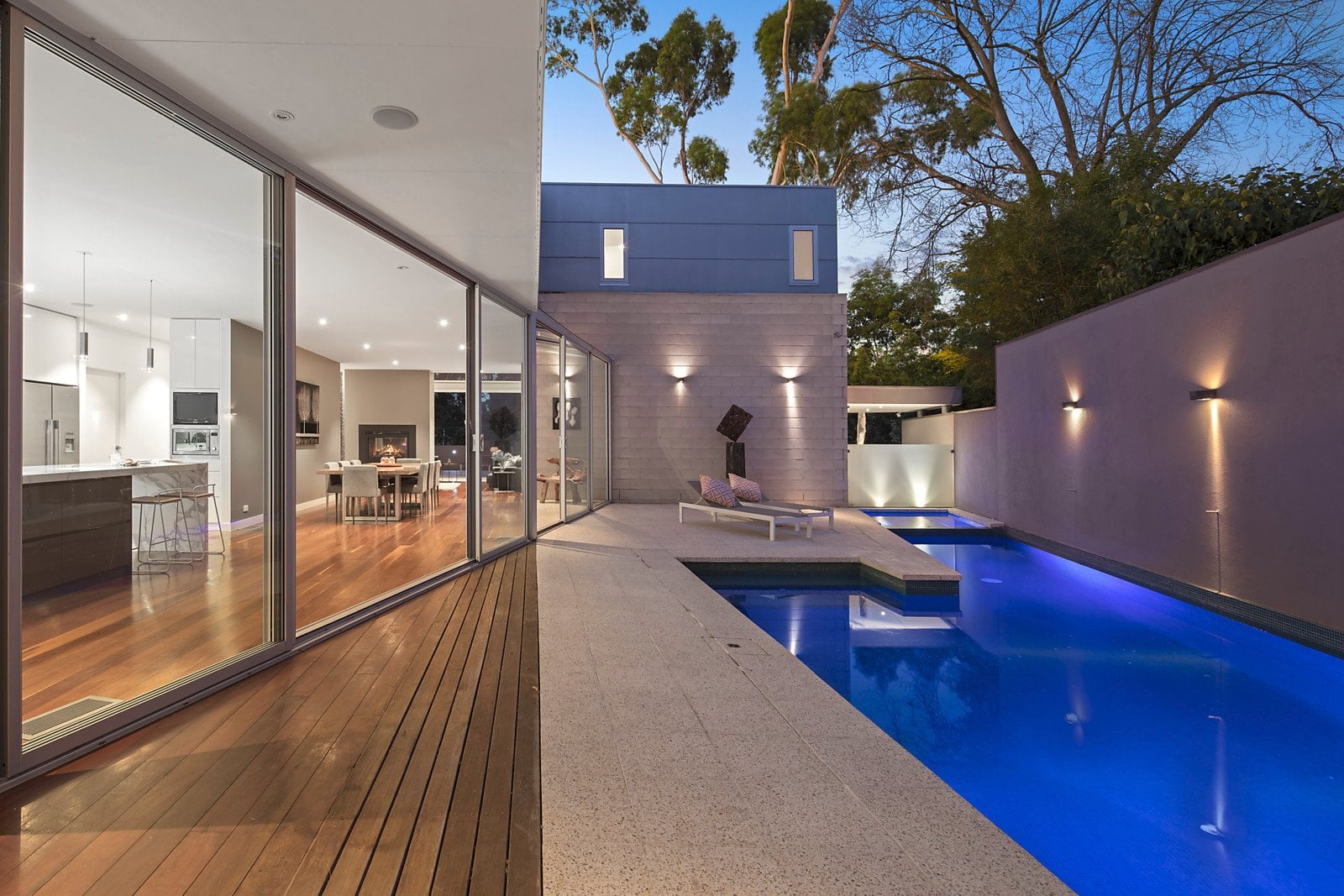 Lap pool alongside glass sliding doors, lit at dusk, Eaglemont