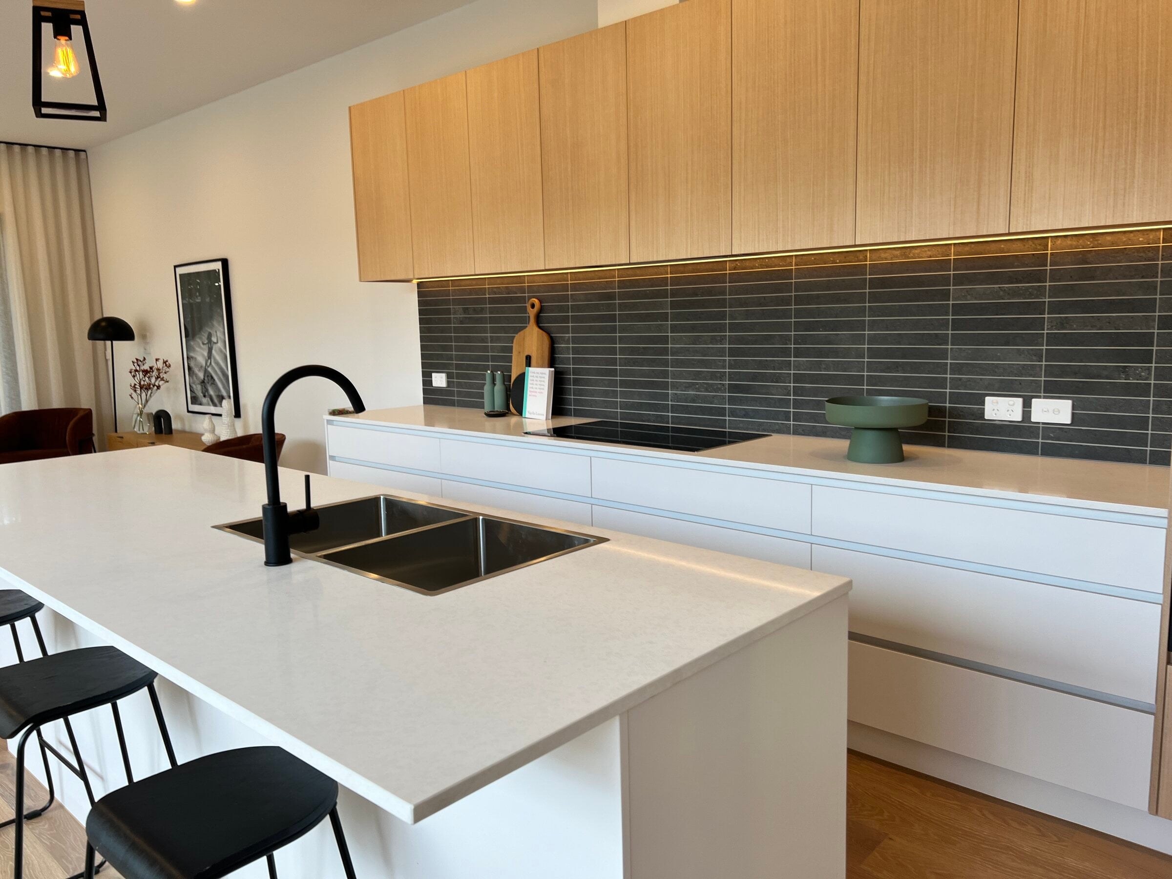 Kitchen with a white island, timber overhead cabinets and dark tiles, Hampton